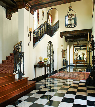 Grand foyer with checkered marble floor and staircase